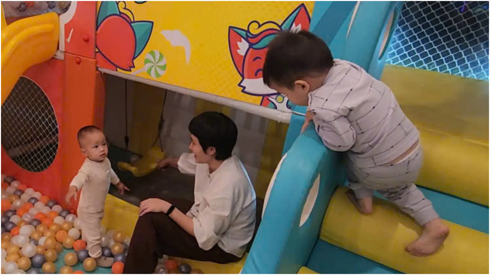 Hai bé trai đang chơi vui vẻ với những chiếc xe ô tô đồ chơi trong một khu vui chơi sáng sủa